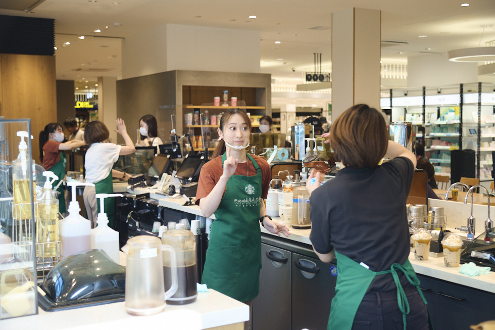 手話やアイコンタクトで意思疎通している店員たち