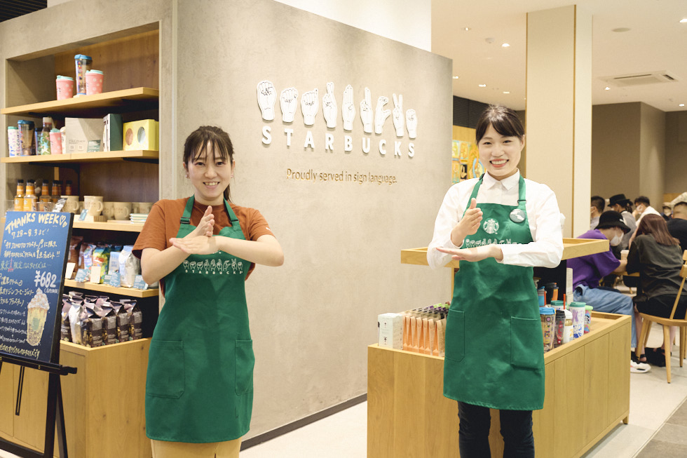 「ありがとう」の手話をしているスターバックス コーヒー nonowa国立店の２人の店員